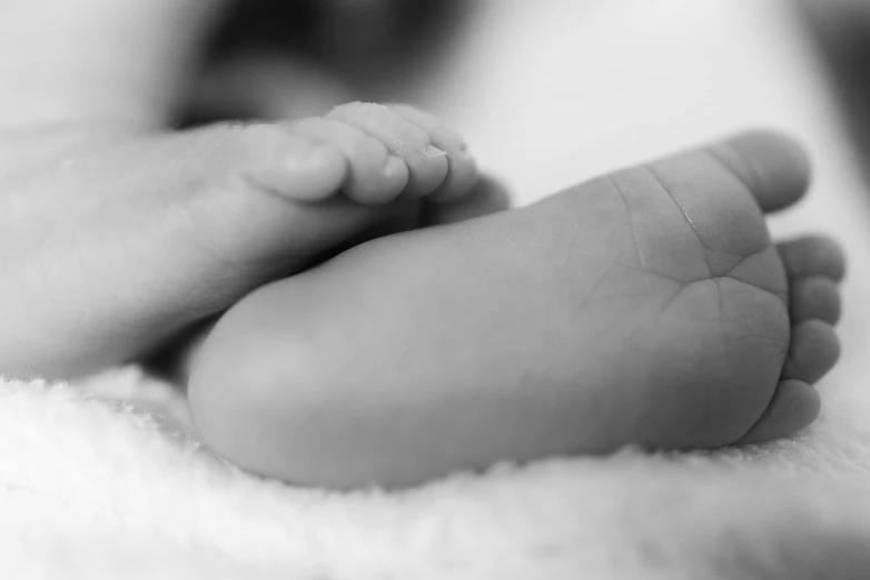 a small baby foot on top of a blanket