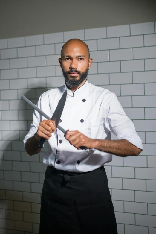 a chef with a beard holding a knife