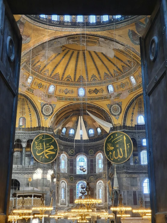 the inside of a large building that has some gold decorations and lights