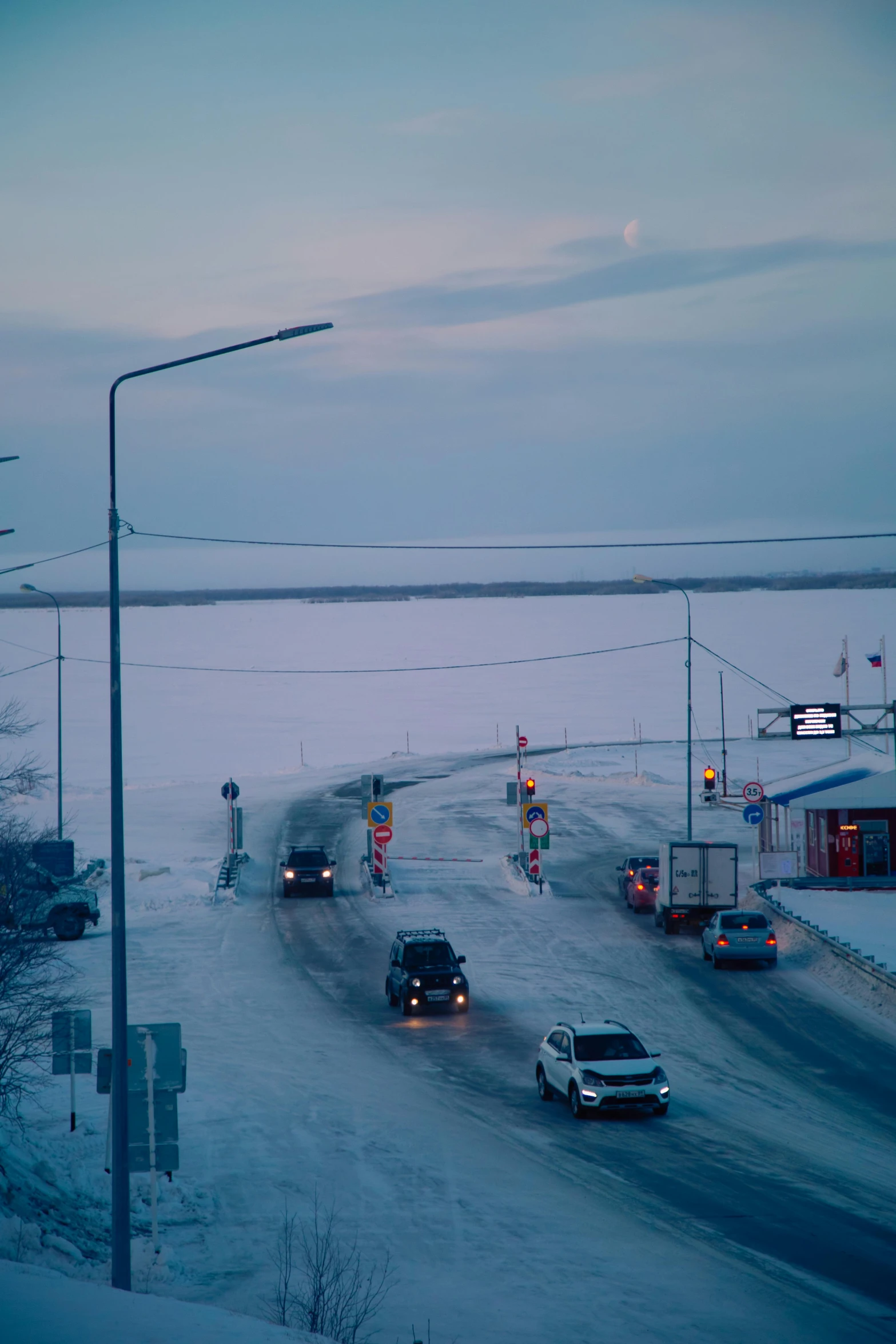 cars travelling on a road near a bus stop