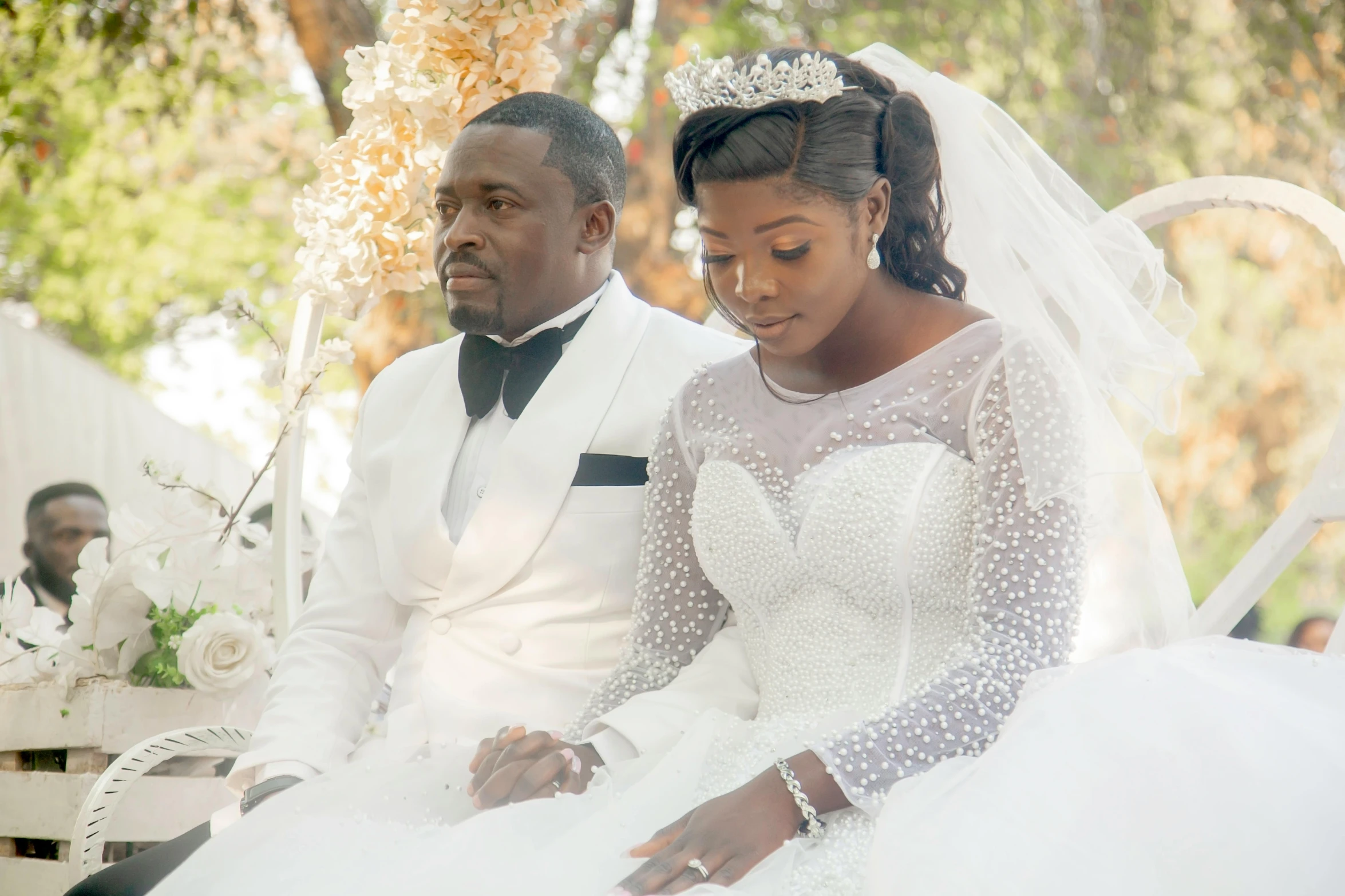 bride and groom sitting on park bench together