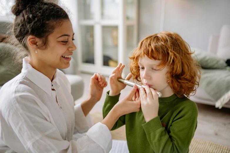 a girl is painting another 's face