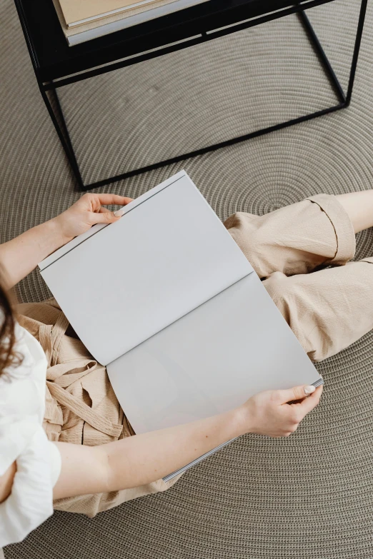 a person sitting on a floor with a laptop in their hand