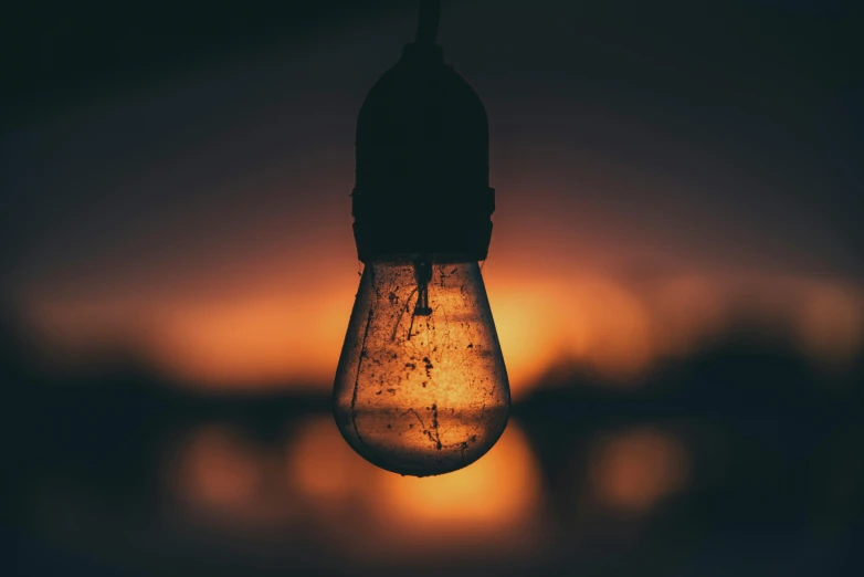 light bulb hanging from a string with blurred background