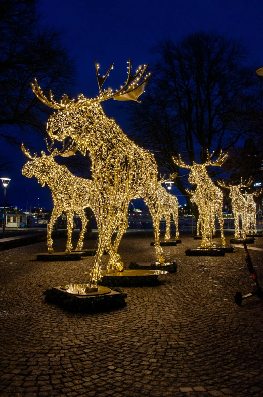 there are christmas lights hanging on the statue of reindeers