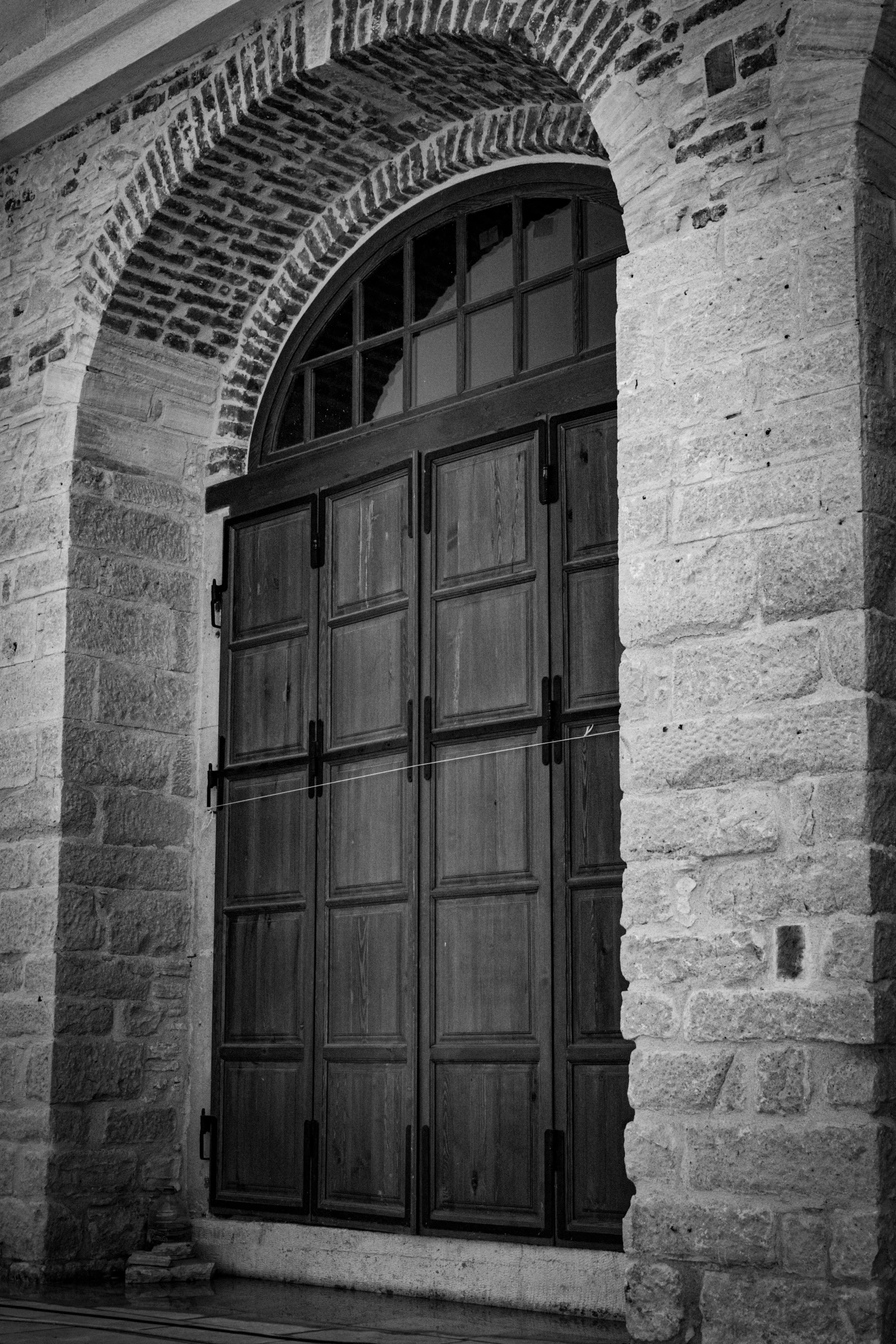 a wooden door has a brick wall behind it