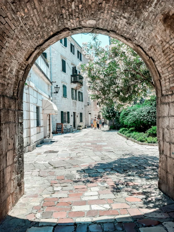 an arched window to a street that has red brick