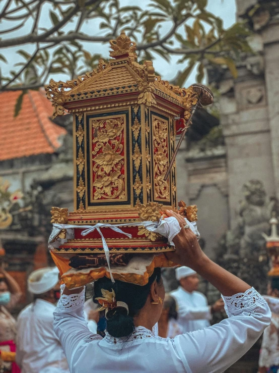 people dressed in traditional clothing and carrying items in the streets