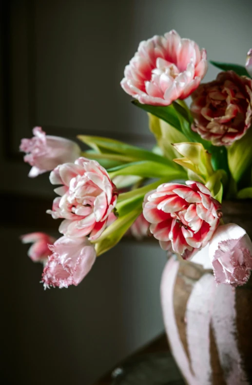 pink and white flowers in a large metal vase