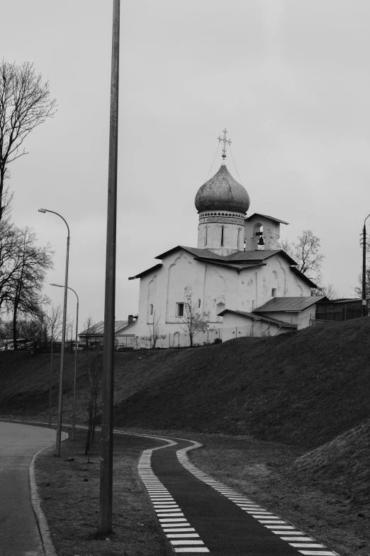 a white church on a hill near street lamps