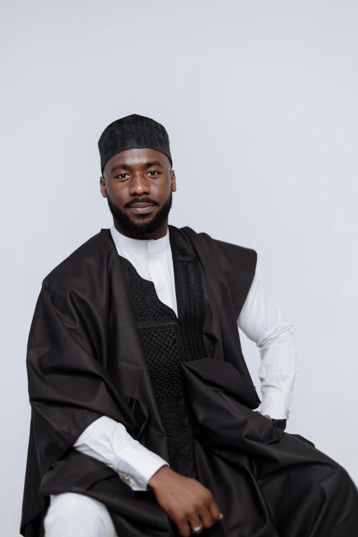 a man sitting down wearing a black vest