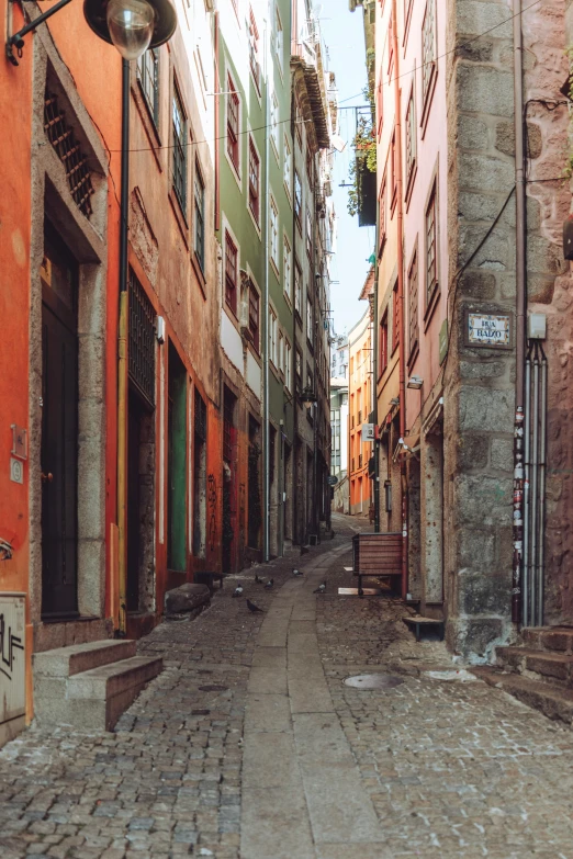 the empty city street is narrow and has old brick buildings