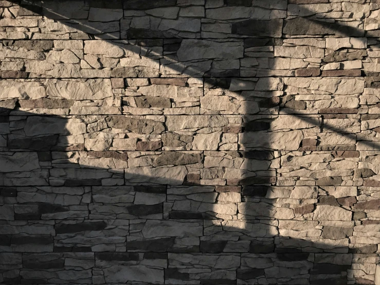 a large stone wall is next to a street light