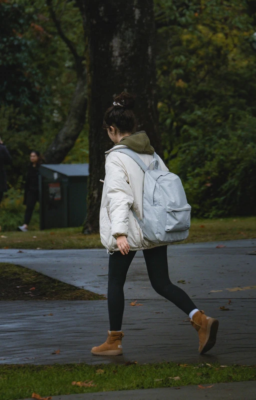 woman with backpack walking on road in rainy day