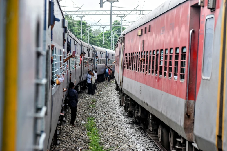 people are looking at two trains and one person is getting on the other