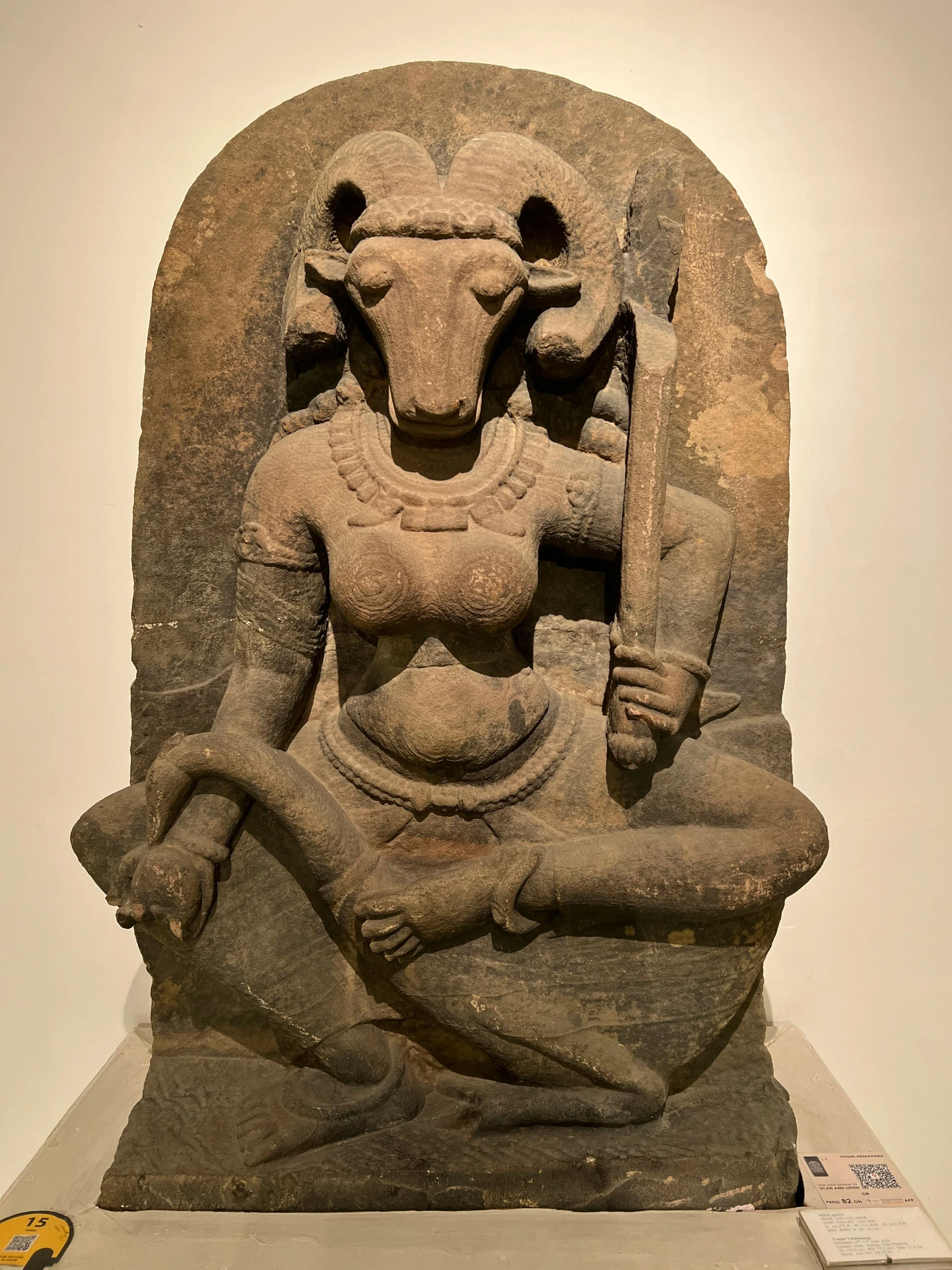 a stone statue depicting an old woman with a staff