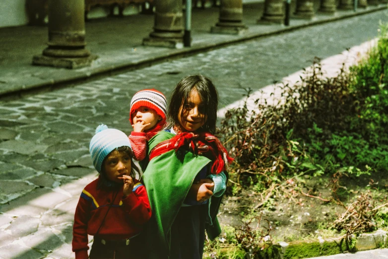 three little girls pose for the camera in a city street