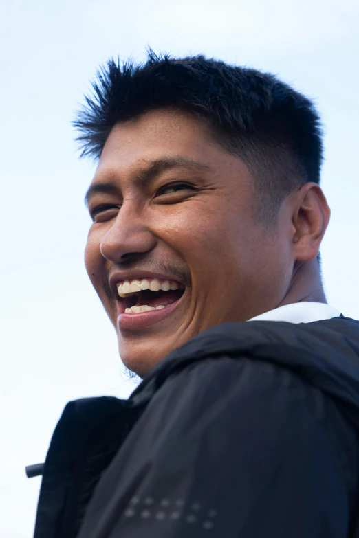 a smiling young man has black hair