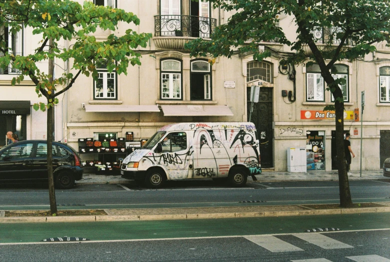 a van painted with graffiti parked on the side of a street