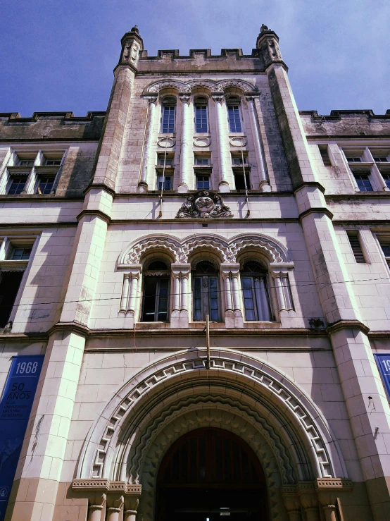 the front of a large stone building with arched doors