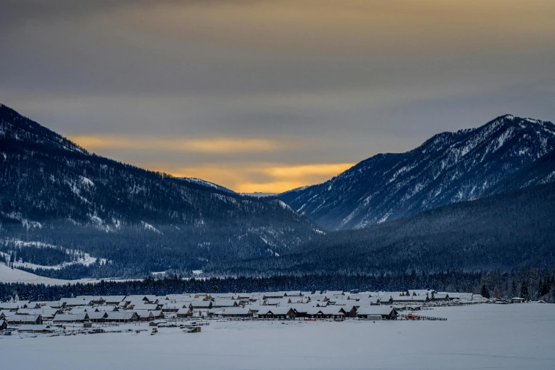 snow covered mountains with houses in the distance