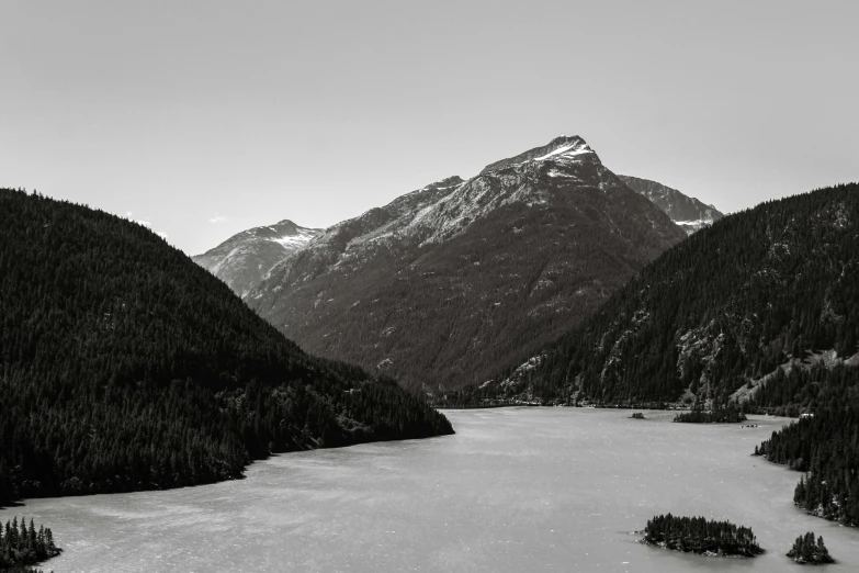 black and white pograph of mountains overlooking a lake
