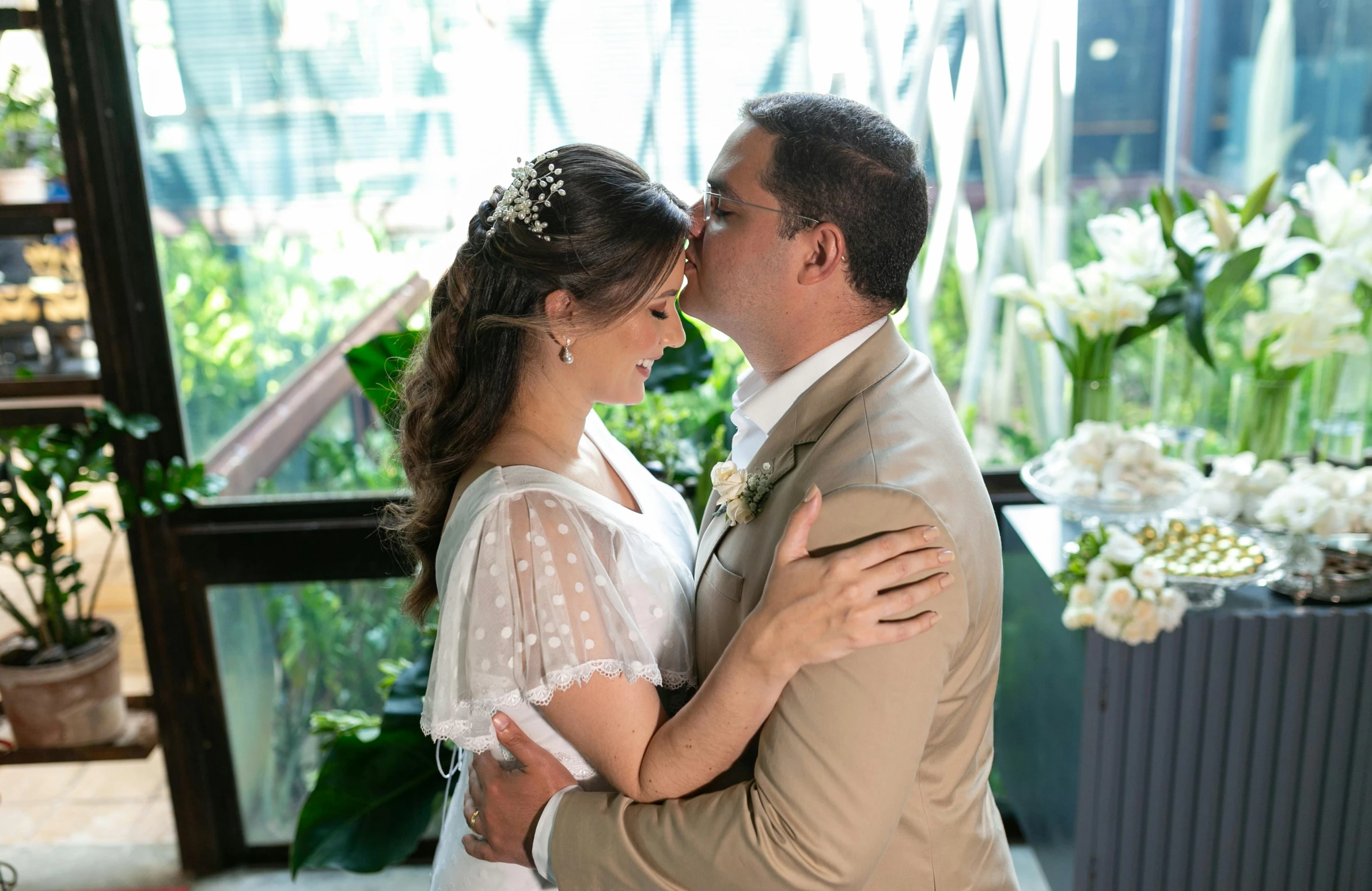 a man and woman on their wedding day emcing in front of a window