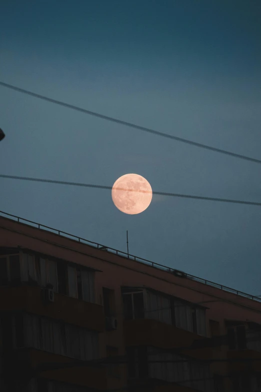 a very big bright pink moon in the sky