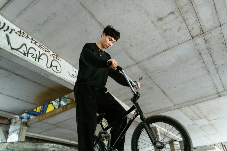 young man standing on top of a bike