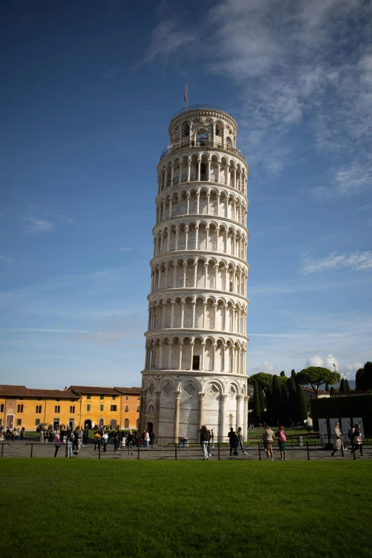 the tall tower of pisa sits tall and has many people on it