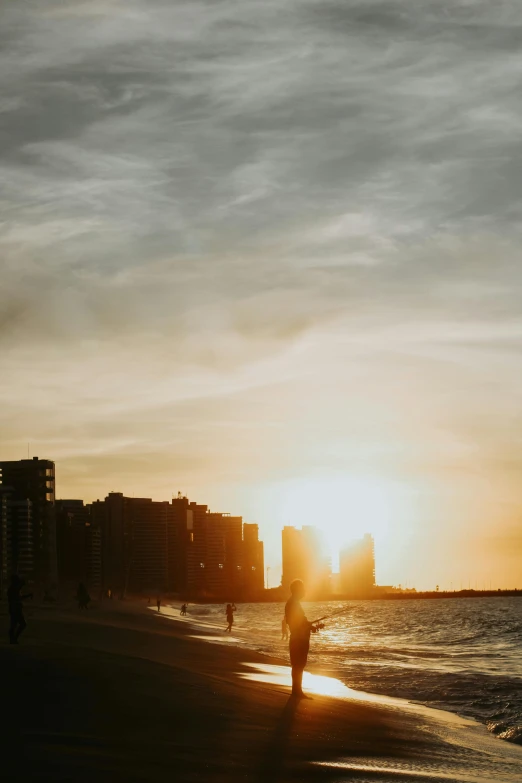 a man is walking across the beach near the water