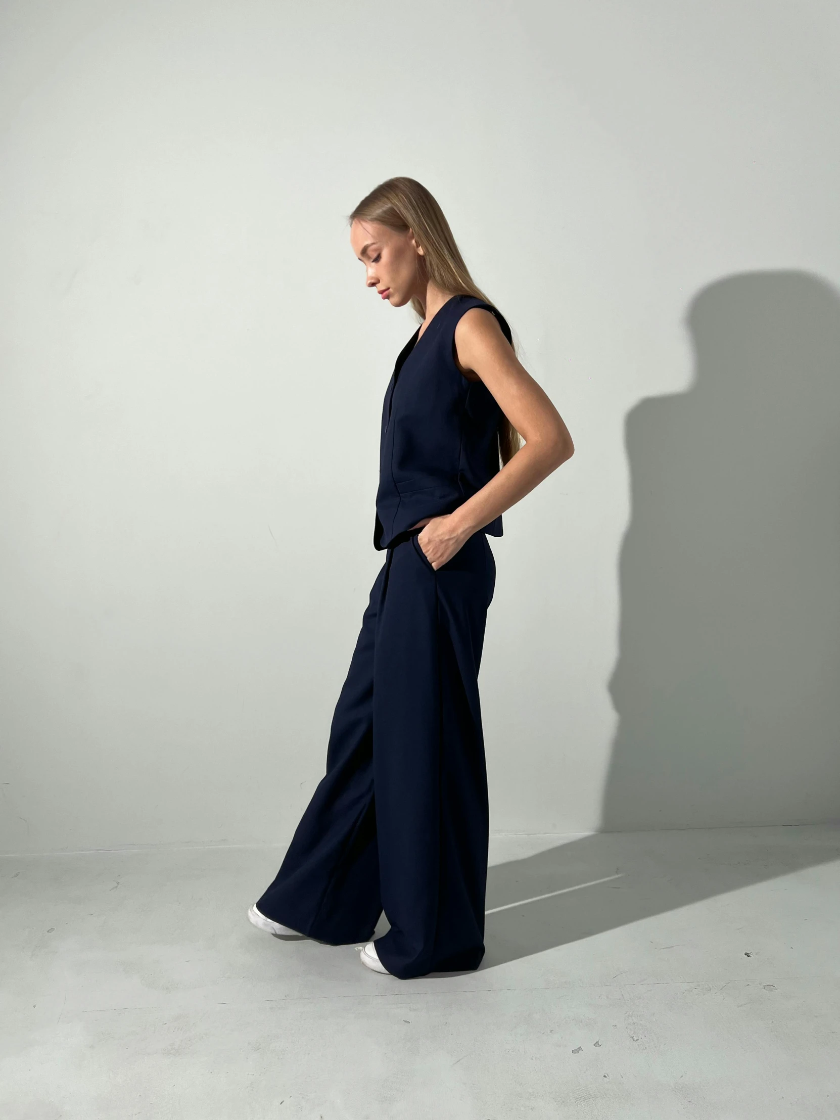 a woman in dark blue jumpsuit standing up