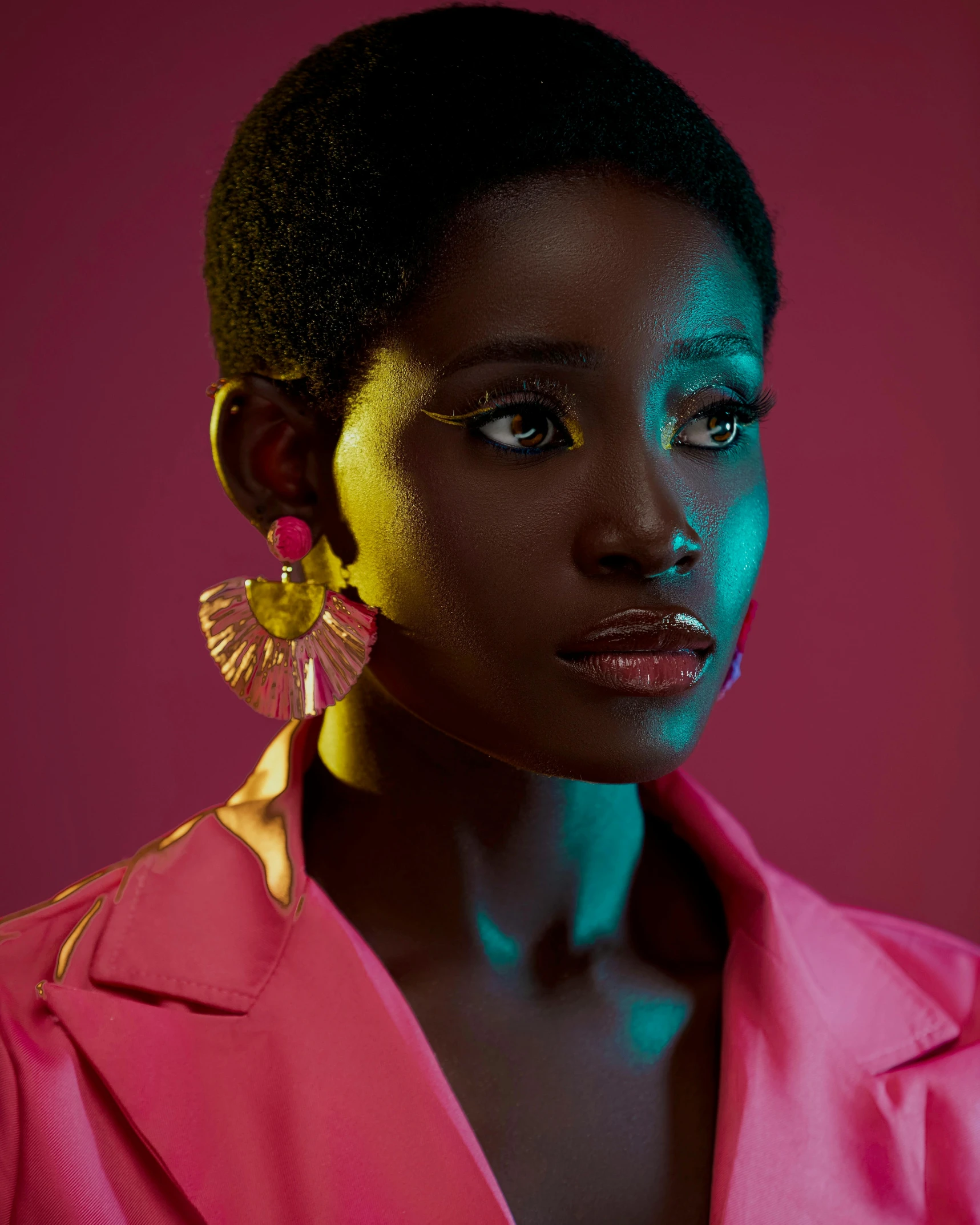 a woman wearing some yellow earring and pink jacket