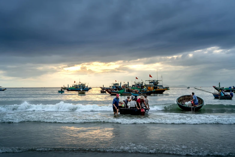 four boats with people standing on the shore