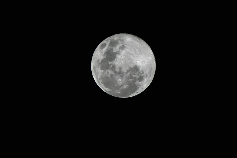 an airplane is flying under the moon in a clear sky