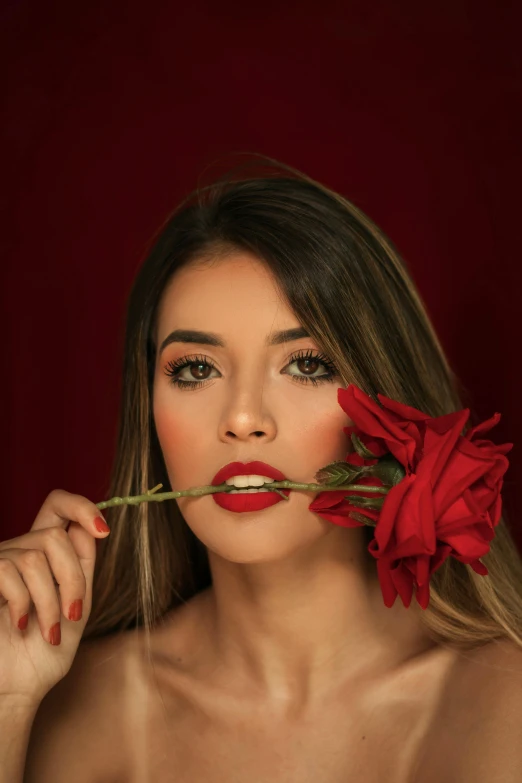 a woman holds a rose above her mouth