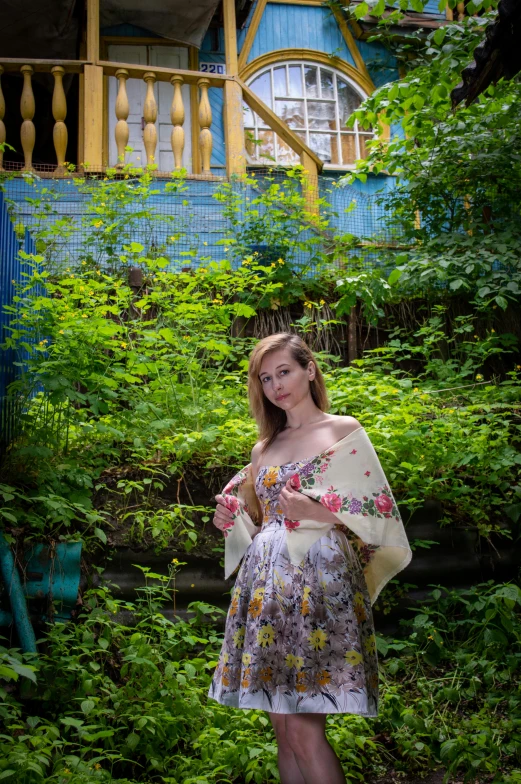 the woman in the dress is standing in front of a house