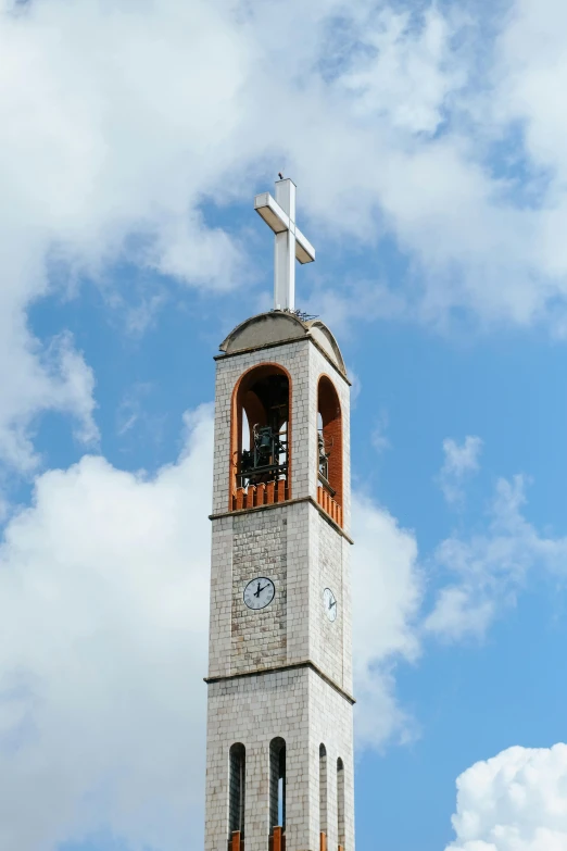 the church steeple has a clock and a cross on it