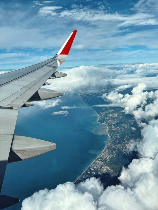 a view out the window seat on an airplane looking over the clouds below