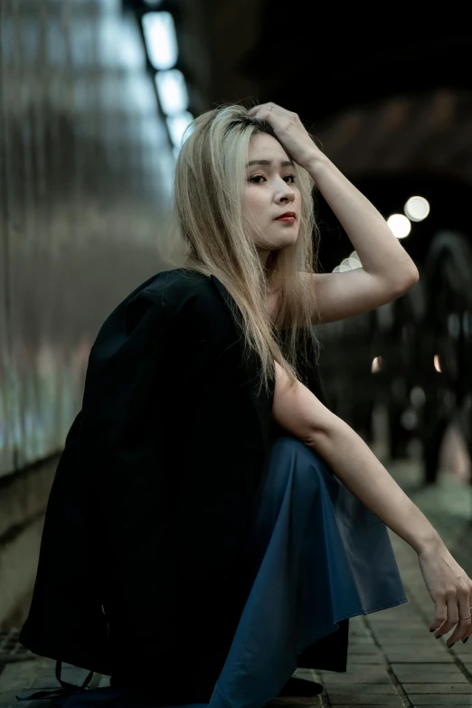 a woman sitting on the ground looking into a tunnel