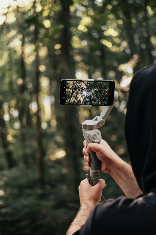 a man is in the woods using a camera to record an image