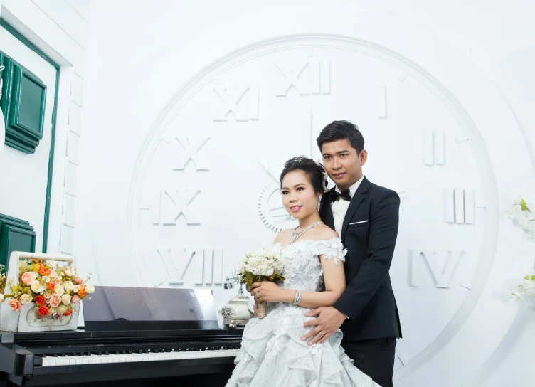 a couple posing with a piano near a wall