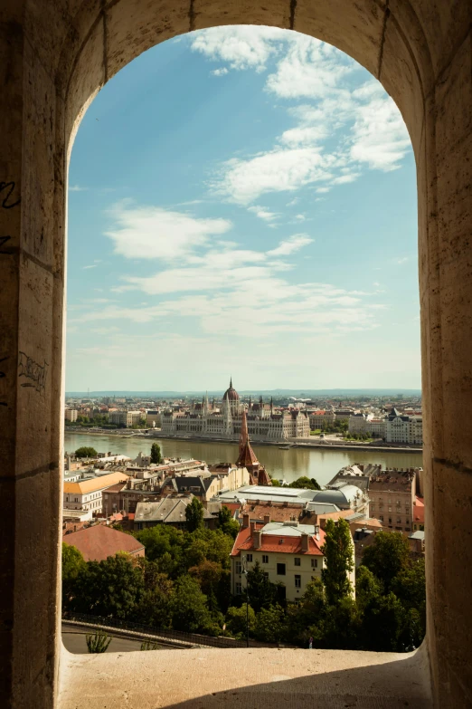 a city from an arched window with a clear sky