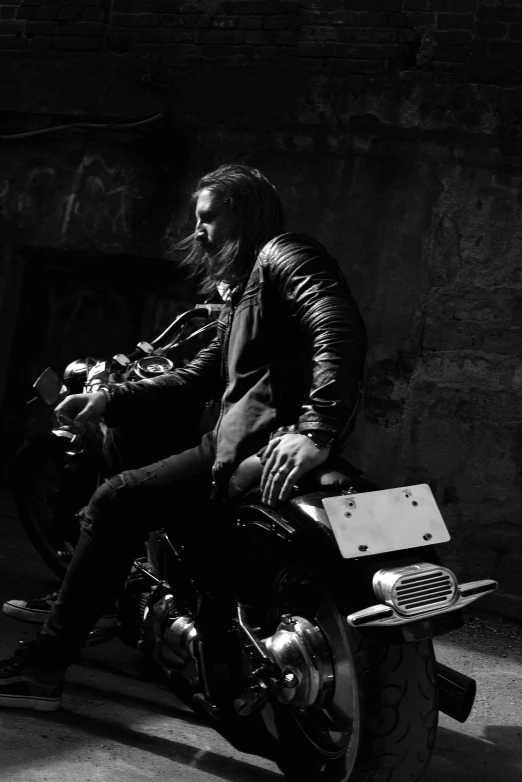 black and white image of a biker in leather jacket on a motorcycle