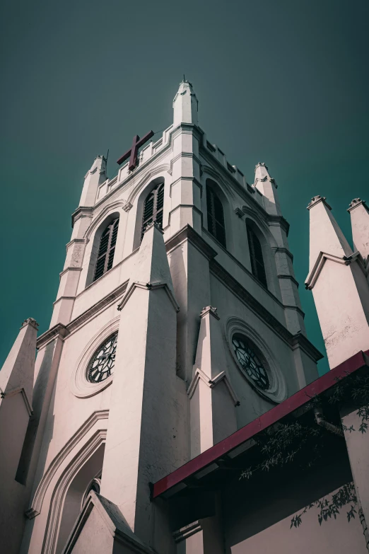 a tall white church with a clock at the top