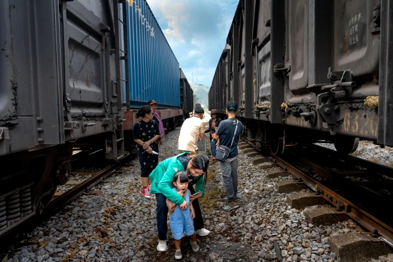 several people look at the back of a train while others stand on the side