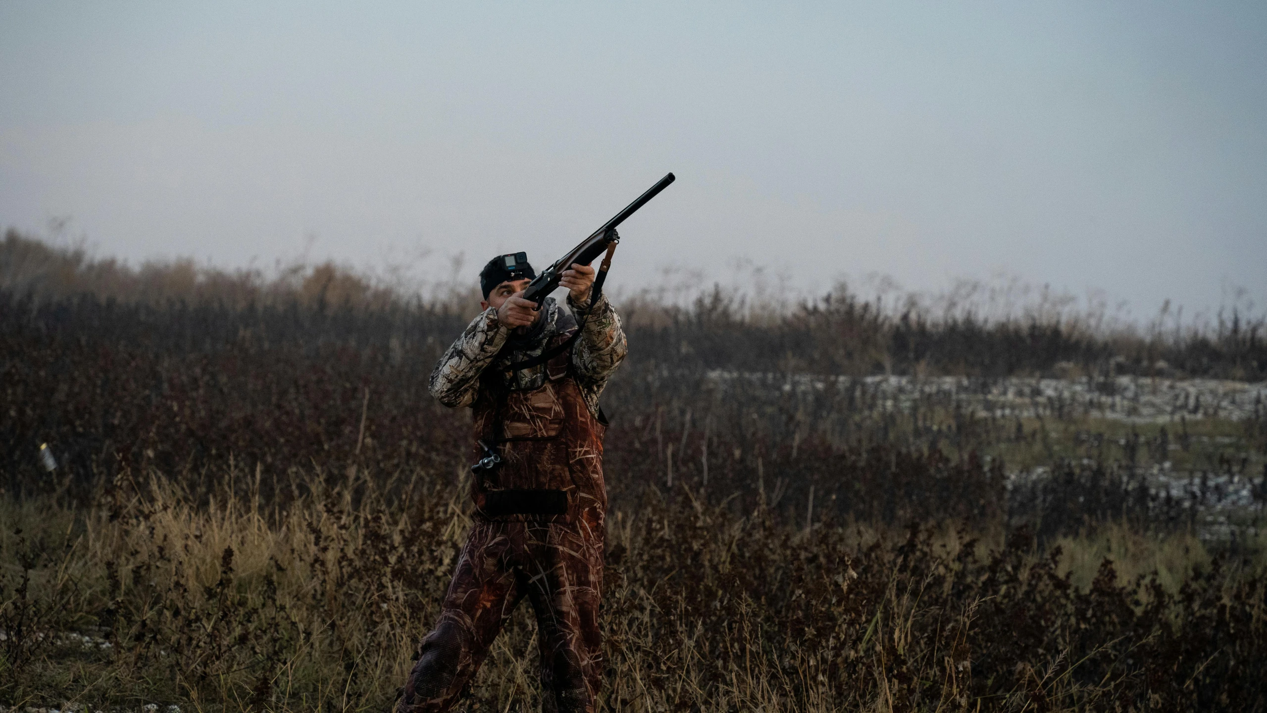 a hunter holding a rifle in the field