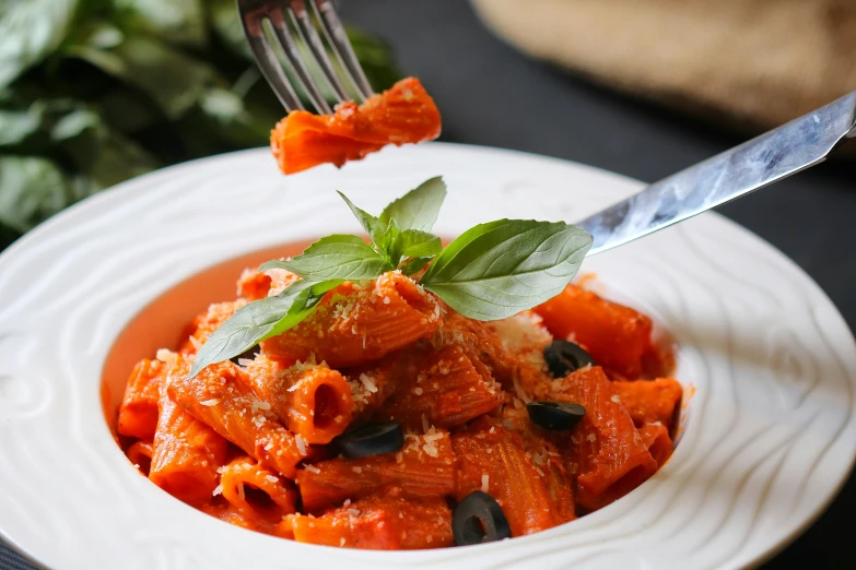 a fork in a plate of riganzo sauce on a table