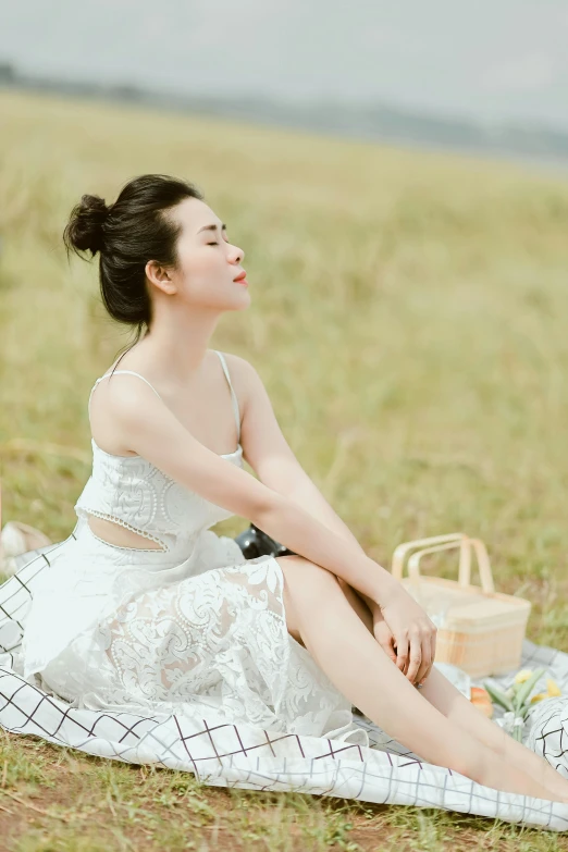 a woman with a picnic blanket on the grass