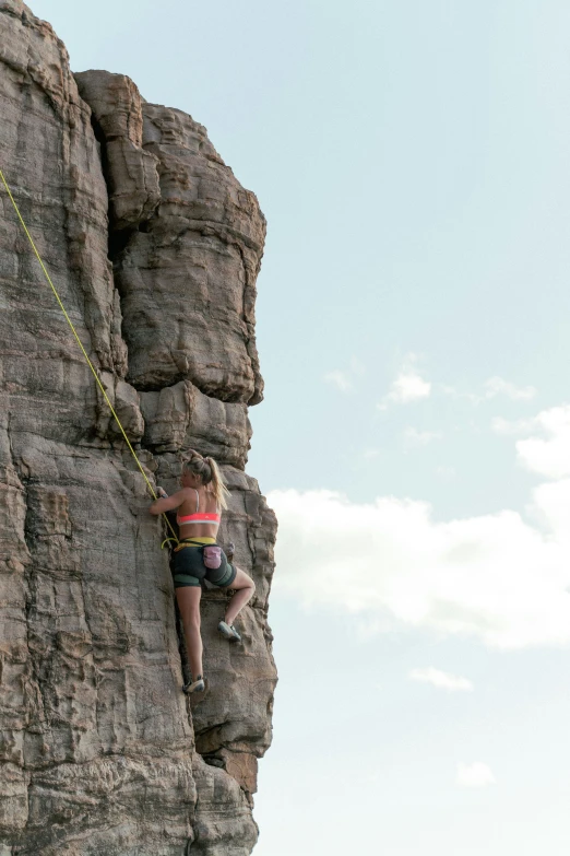 a person on a rock climbing while wearing an onisport helmet